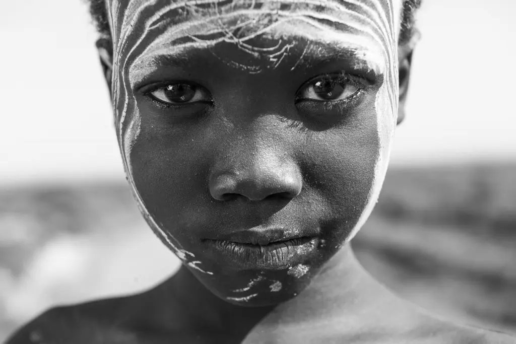 Ein Kind schaut in die Kamera. Das Bild ist in schwarz und weiß