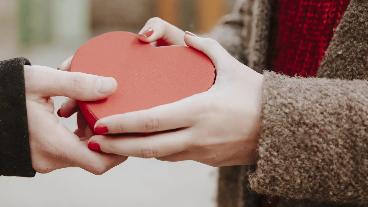 Zwei Menschen halten eine Herz-Schachtel in der Hand