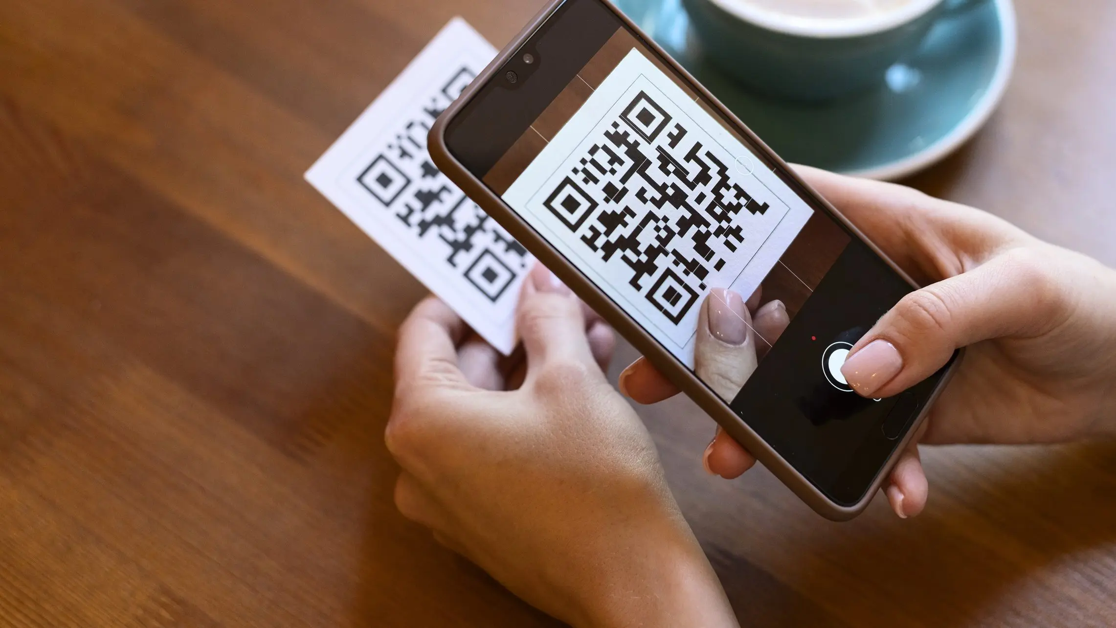 Frau scannt QR-Code mit Smartphone ab.