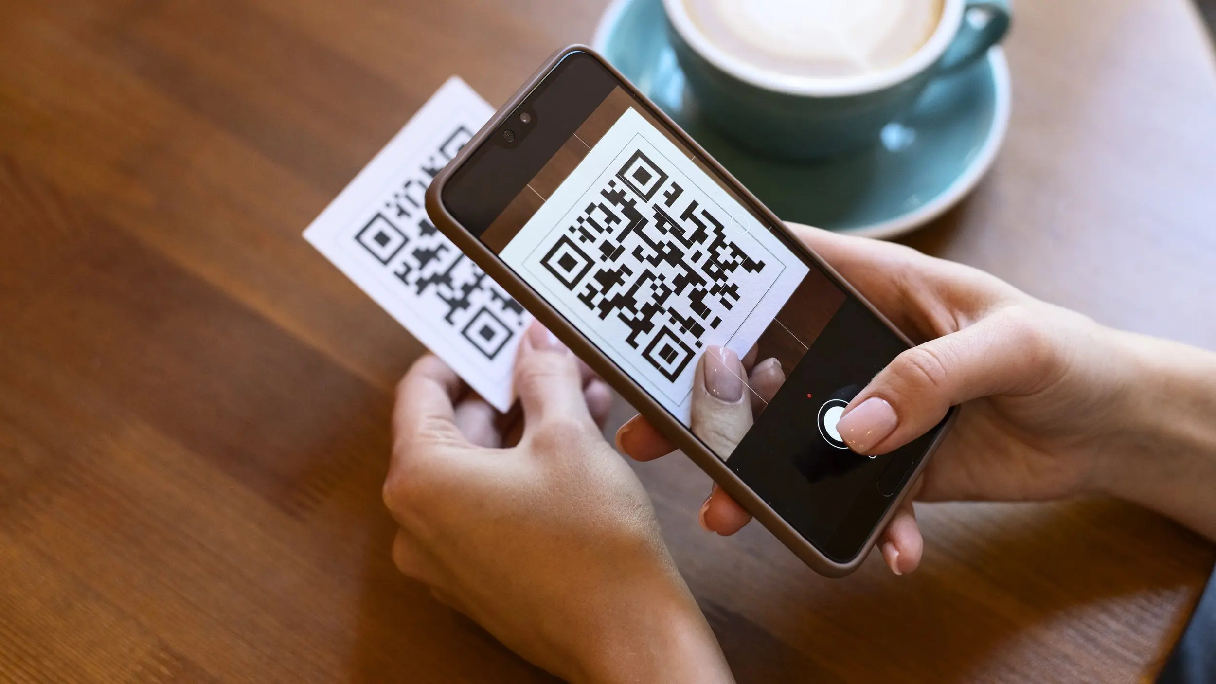 Frau scannt QR-Code mit Smartphone ab.