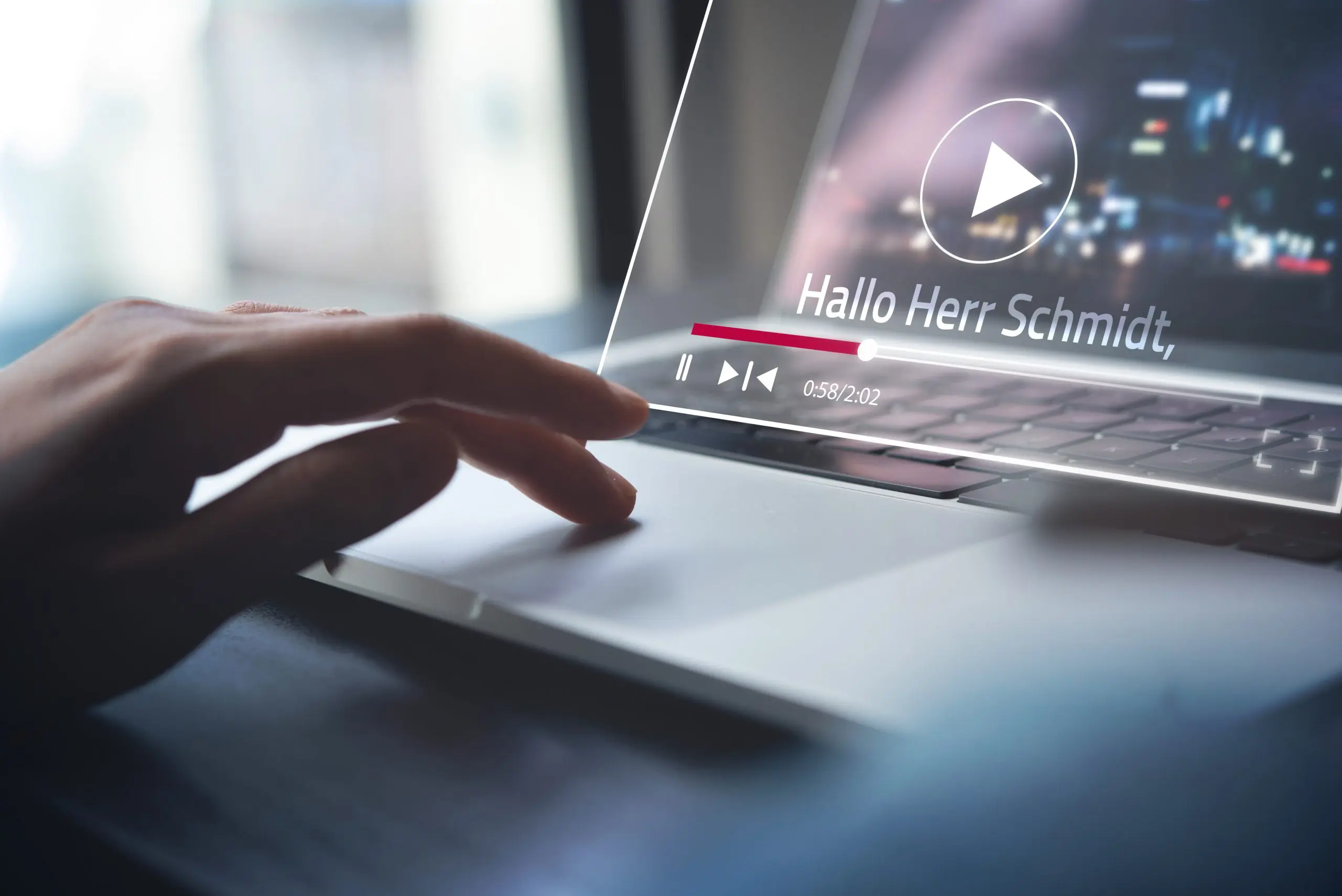 Eine Hand auf der Laptop-Tastatur. Am Bildschirm wird ein Video abgespielt