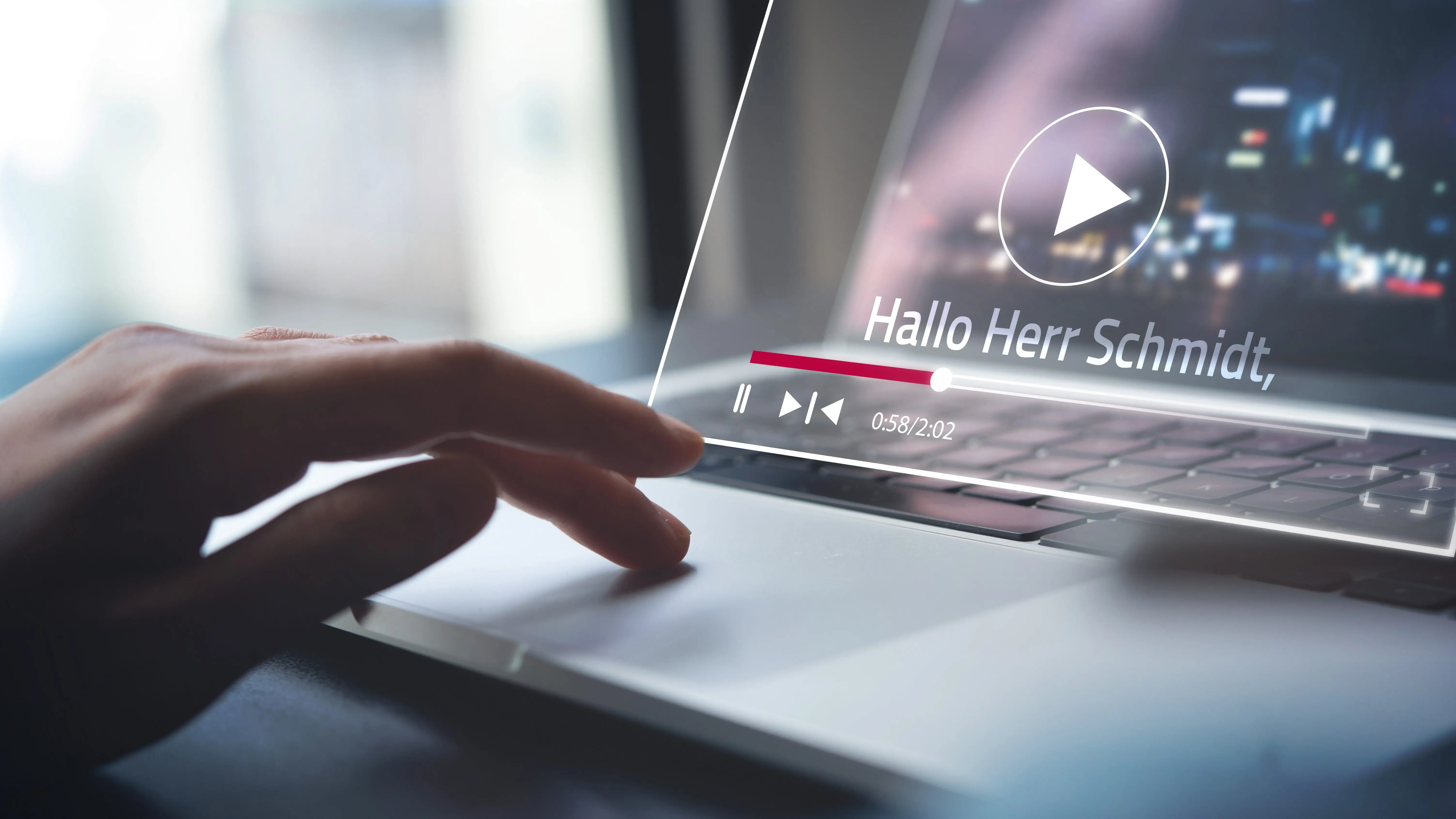 Eine Hand auf der Laptop-Tastatur. Am Bildschirm wird ein Video abgespielt